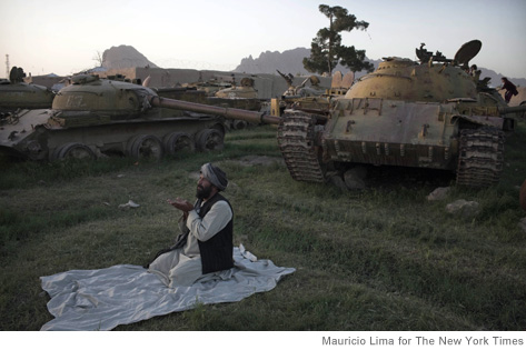 A former Afghan Mujahedeen fighter performs a sunset prayer near Soviet tanks destroyed during the 80's in Kandahar, Afghanistan, on May 9, 2011. Kandahar, the biggest city in southern Afghanistan and a major base for NATO forces, continues to be a target for the Taliban who opened their spring offensive with an attack on the area. (Mauricio Lima/The New York Times)